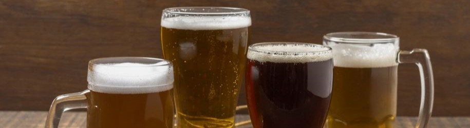 4 verschillende bierglazen op een houten tafel voor het kiezen van het juiste bierglas